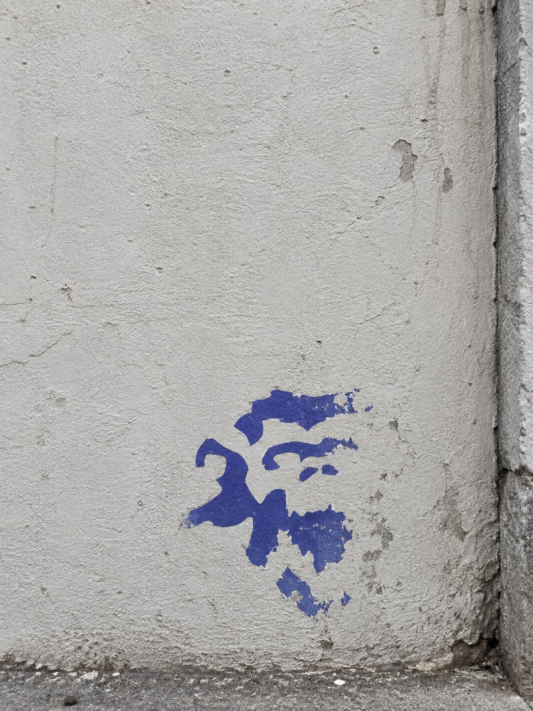 The partially removed outline of an old TORON10 mark on a wall.