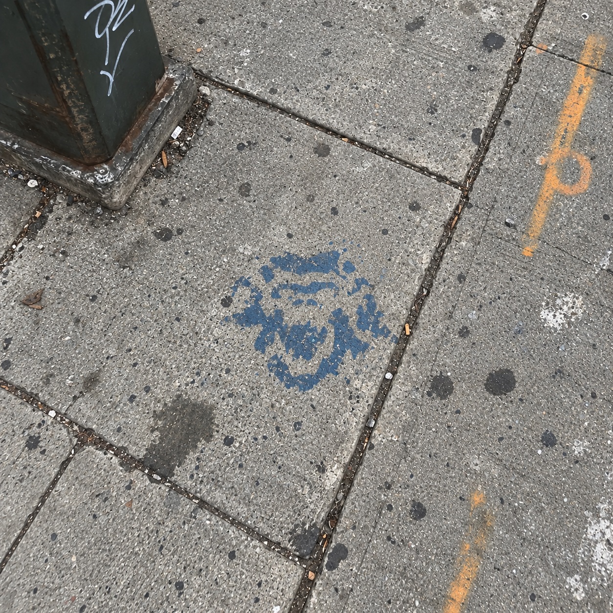 A faint TORON10 trace among repairs and chalk markings on a sidewalk.