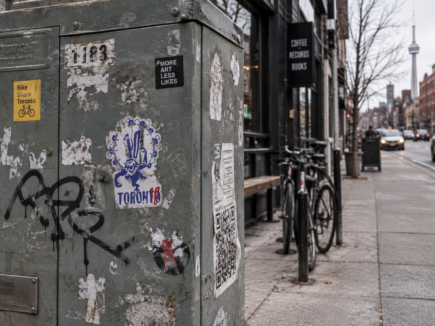 A small TORON10 sticker on the side of a scuffed street utility box.