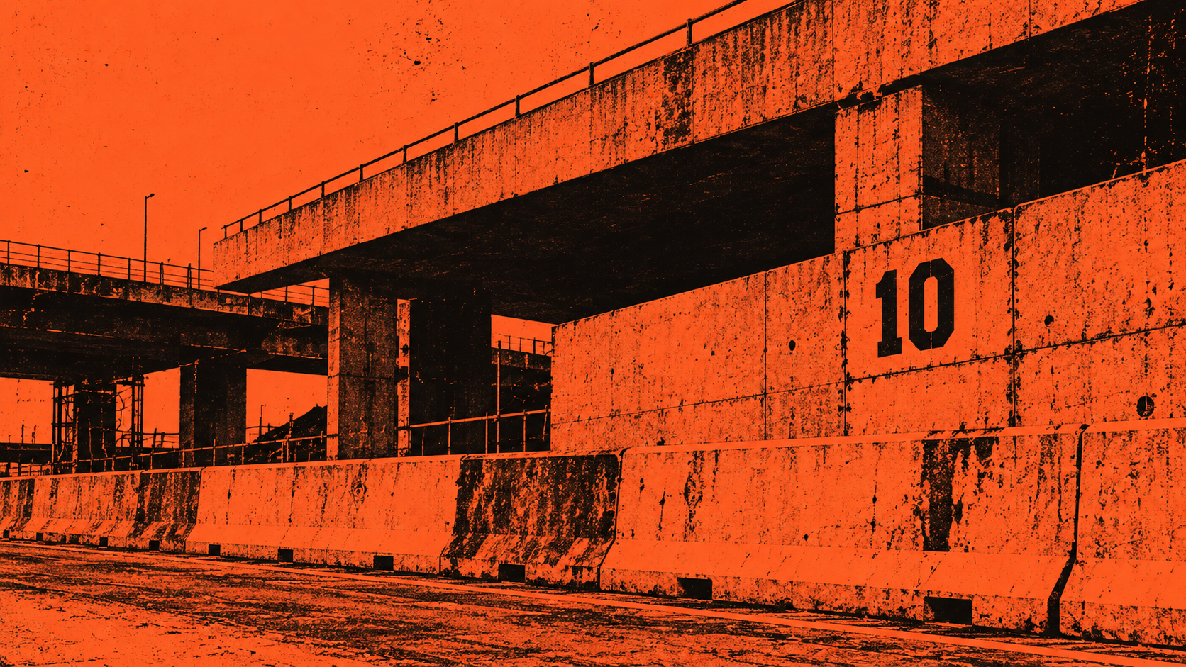 Orange and black rail corridor running beneath a concrete overpass